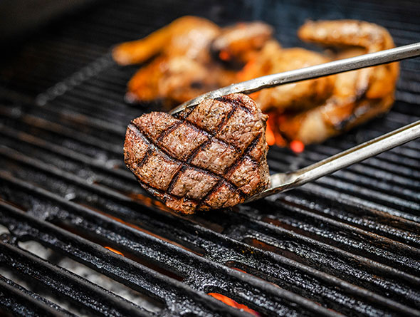 Steak being flipped on grill image